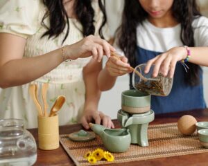 Close-up of mom brewing tea together with her daughter