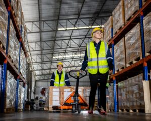 Warehouse industrial stock storage, Team warehouse worker wear safety uniform push load cart product to shelf in warehouse store. business logistics and transport.